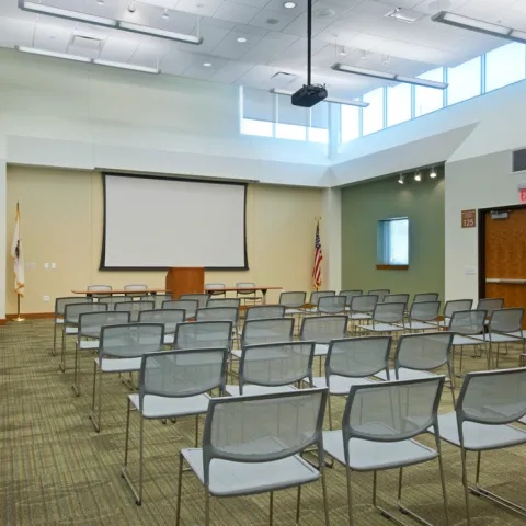 Meeting room with chairs in rows facing screen at front